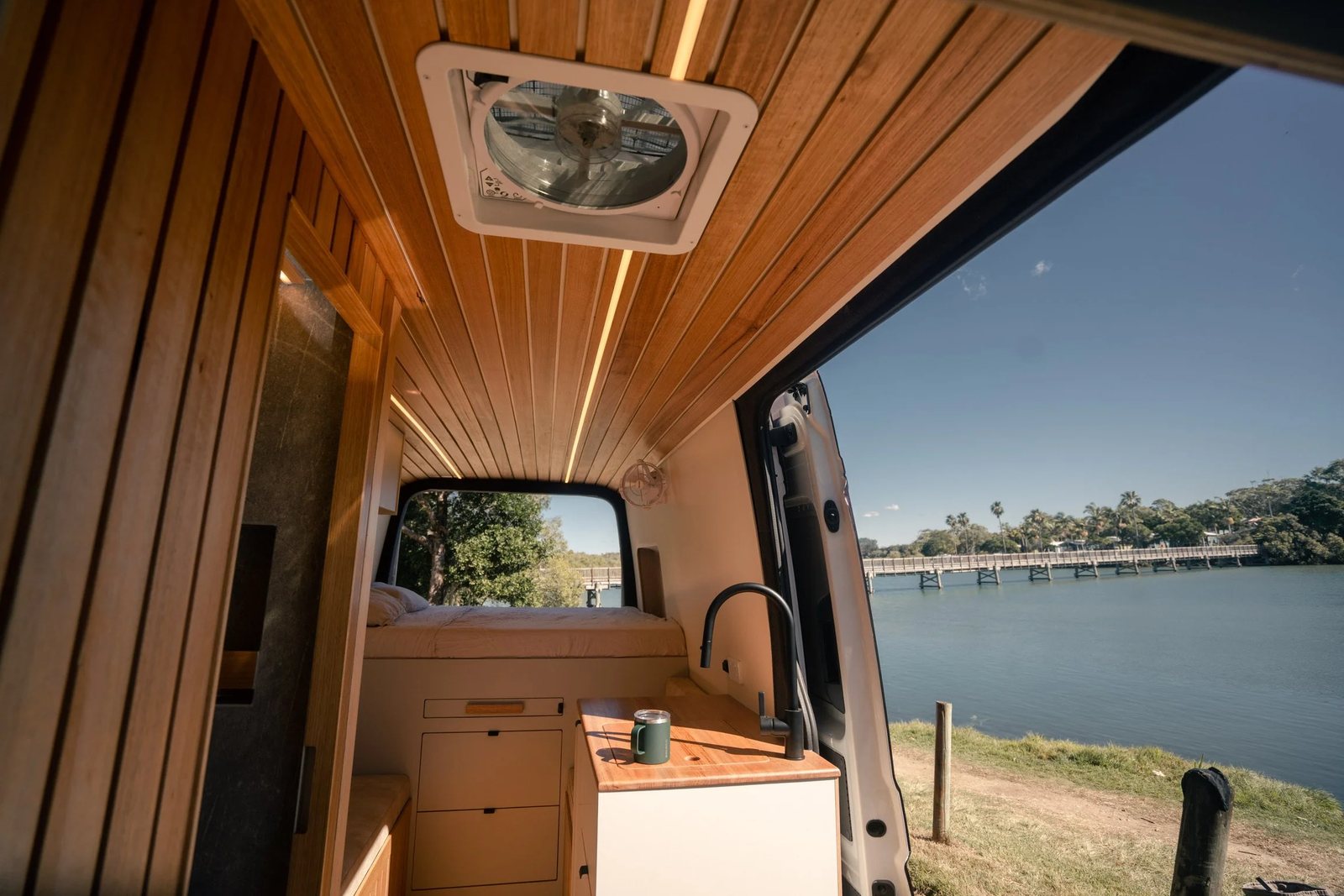 Bondi Van Co — timber campervan interior looking out to the water